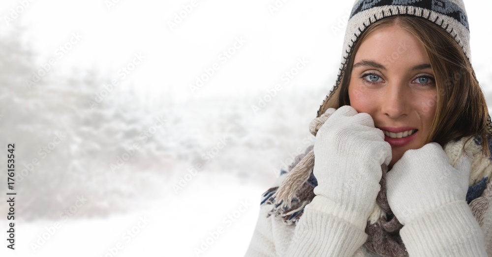 在明亮的雪地森林里戴着手套和帽子的女人