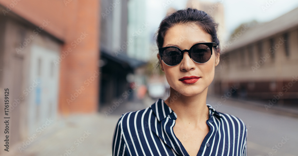 戴着墨镜的女人在城市街道上走在户外