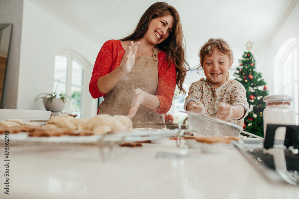 母亲和女儿在做圣诞饼干时玩得很开心。