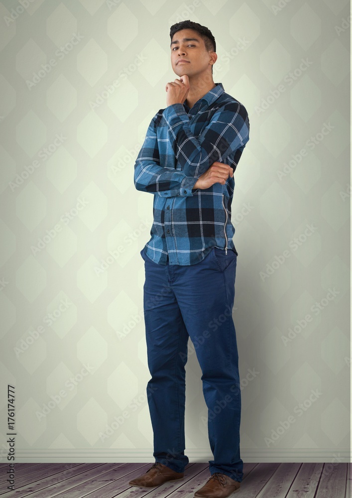 Intelligent man standing thinking against wall in room