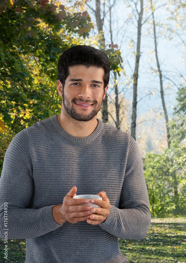 Man in Autumn with cup in forest