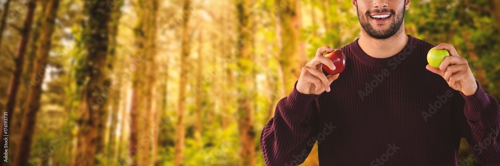 Composite image of portrait of smiling man holding apples