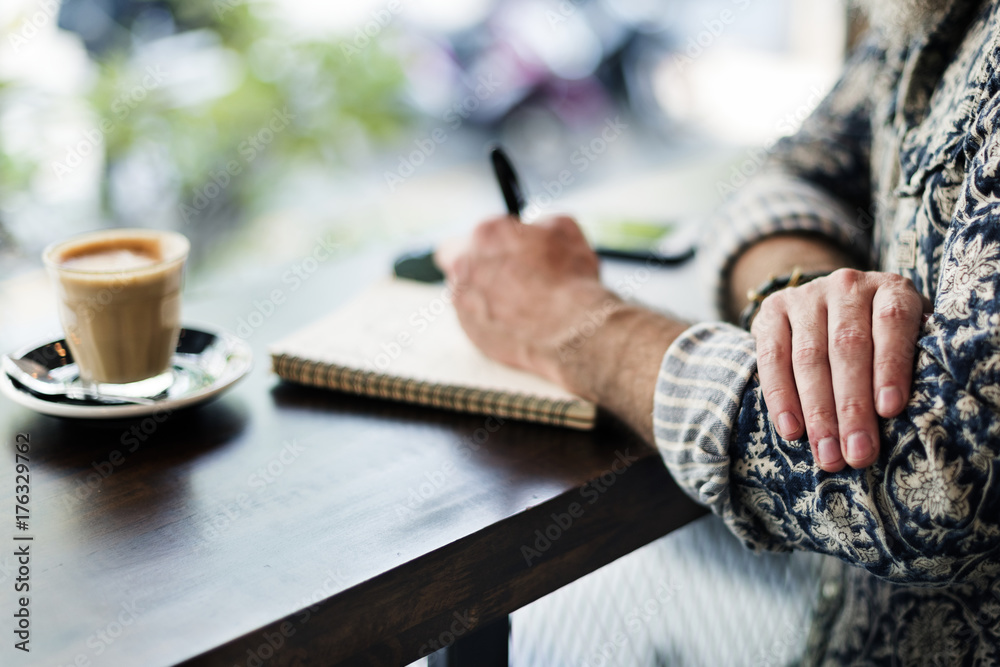 An author making notes in a coffee shop