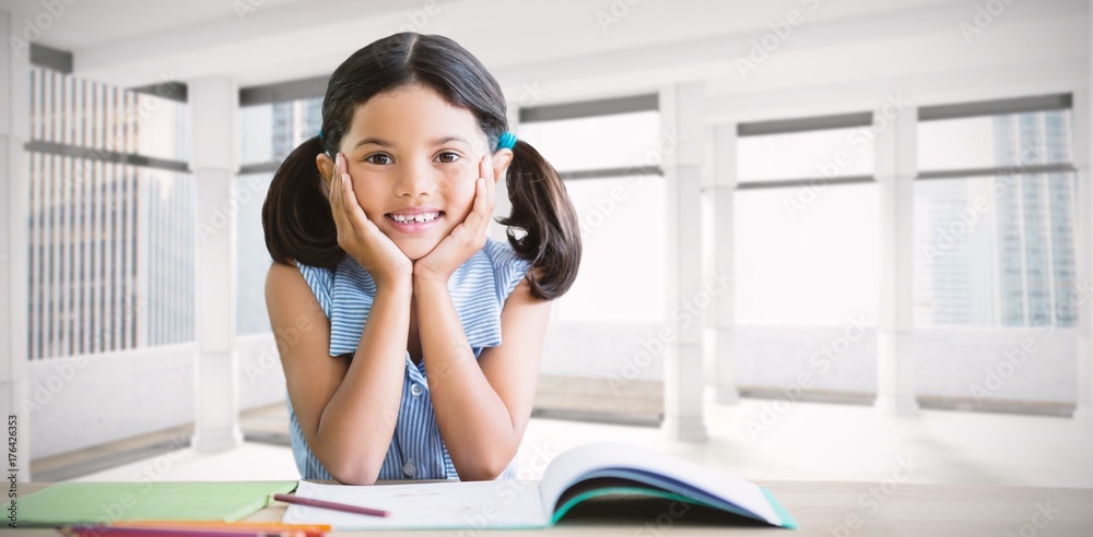 Composite image of portrait of girl doing homework at desk