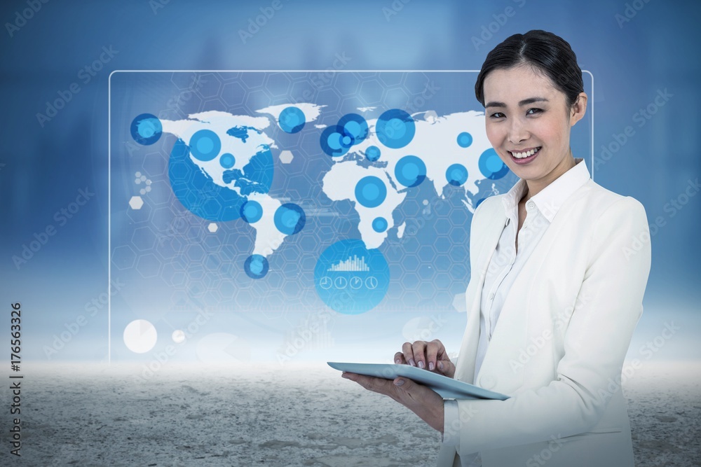 Composite image of smiling businesswoman using her tablet