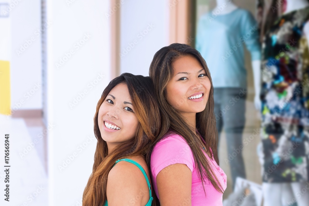 Composite image of two beautiful girls posing for the camera 