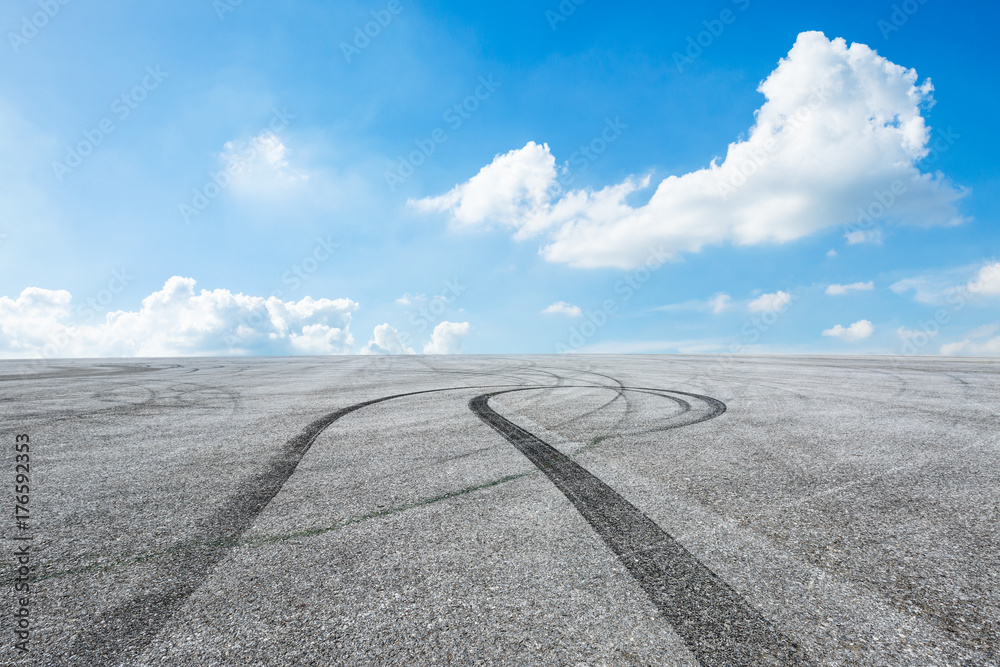 Asphalt road circuit and sky clouds with car tire brake