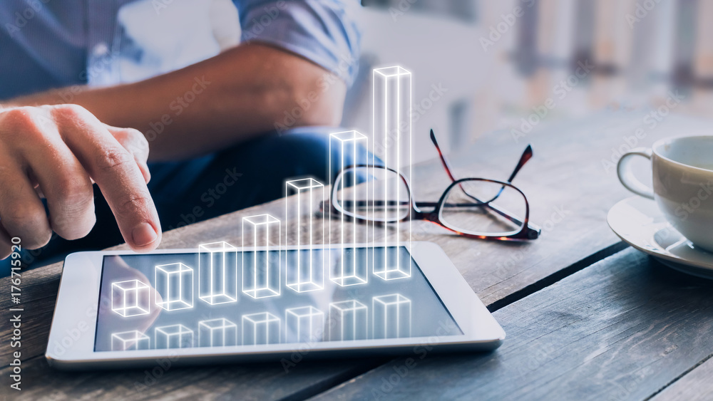 Businessman analyzing growing 3D AR chart above tablet computer screen