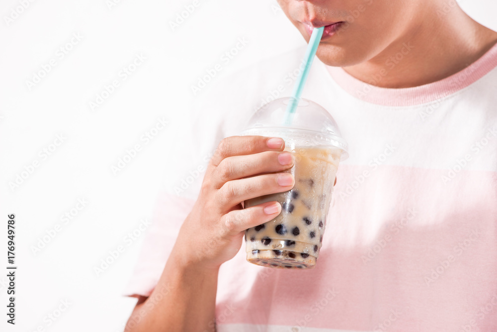 在桌子上的塑料杯里喝浅棕色奶油泡泡茶和黑色木薯珍珠。