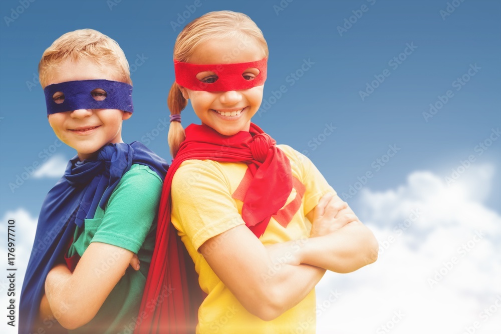 Composite image of happy brother and sister in cape and eye mask