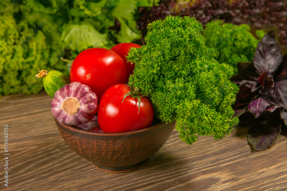 Fresh vegetables. Tomatoes and cucumbers on a wooden table. Delicious vegetarian food. The concept o