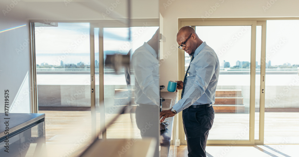 Businessman drinking coffee while preparing breakfast