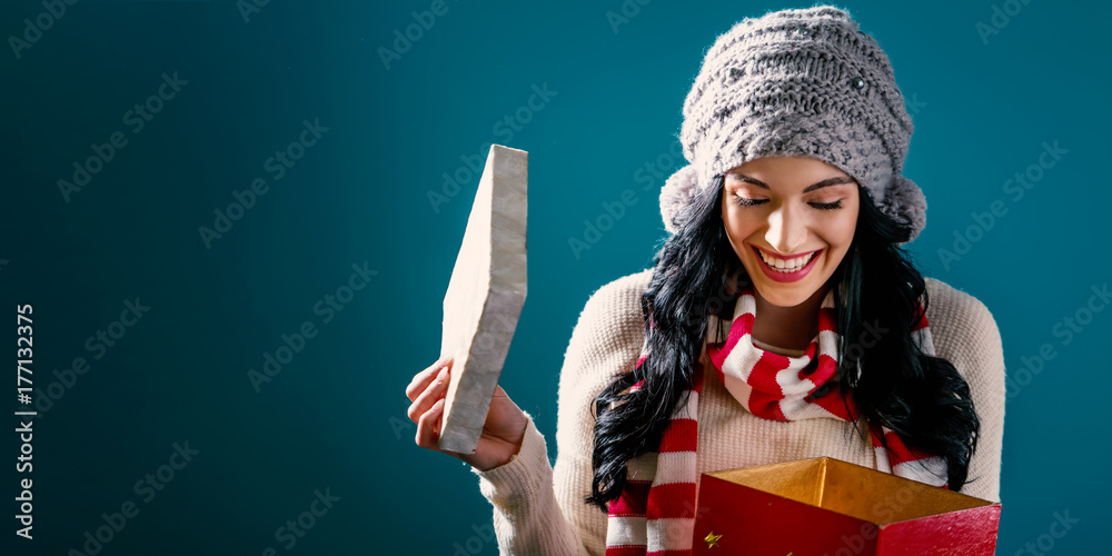 Happy young woman opening a Christmas present box