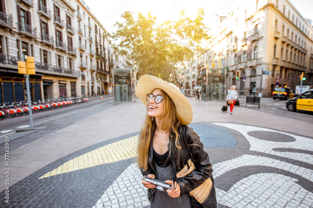 Young woman tourist standing on the central street with famous colorful tiles in Barcelona city