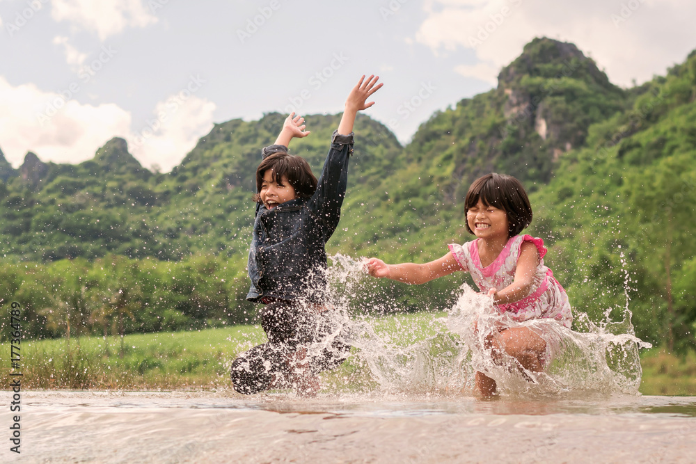 两个女孩在河里玩得很开心。孩子们在户外享受夏天的生活方式