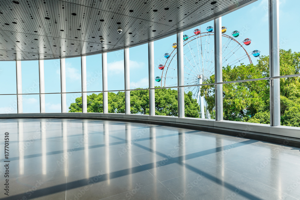 Through the windows to see the green trees and playground Ferris wheel scenery