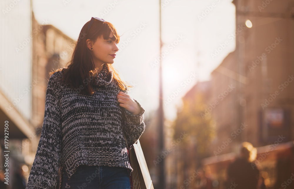 带着购物袋的女人走在街上，城市场景