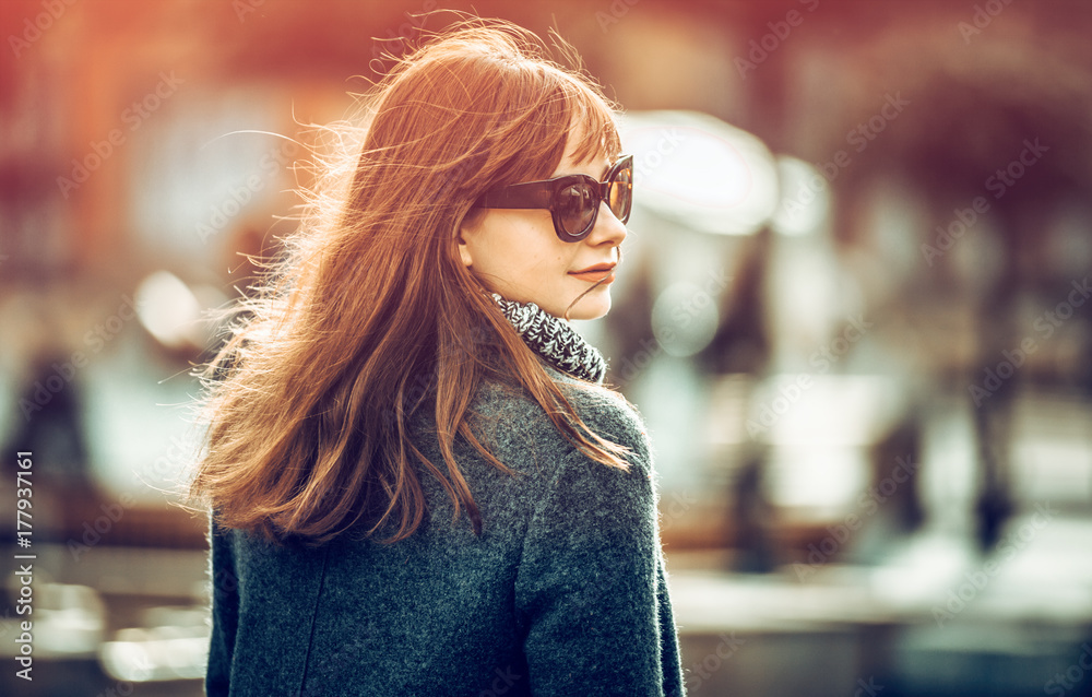 Close up fashion portrait of trendy woman in coat at the city