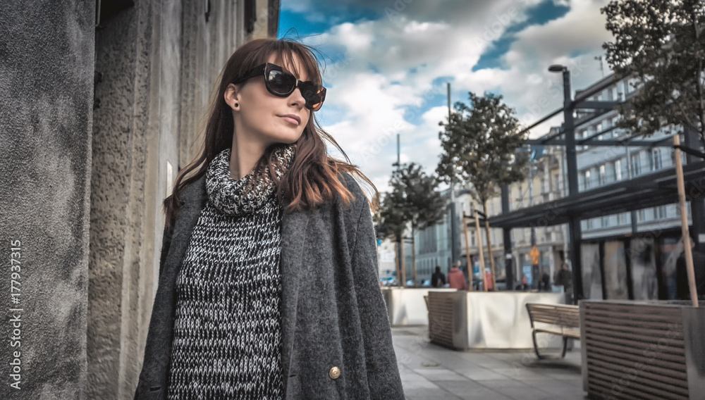 Casual fashion urban scene, trendy woman in coat walking on the street