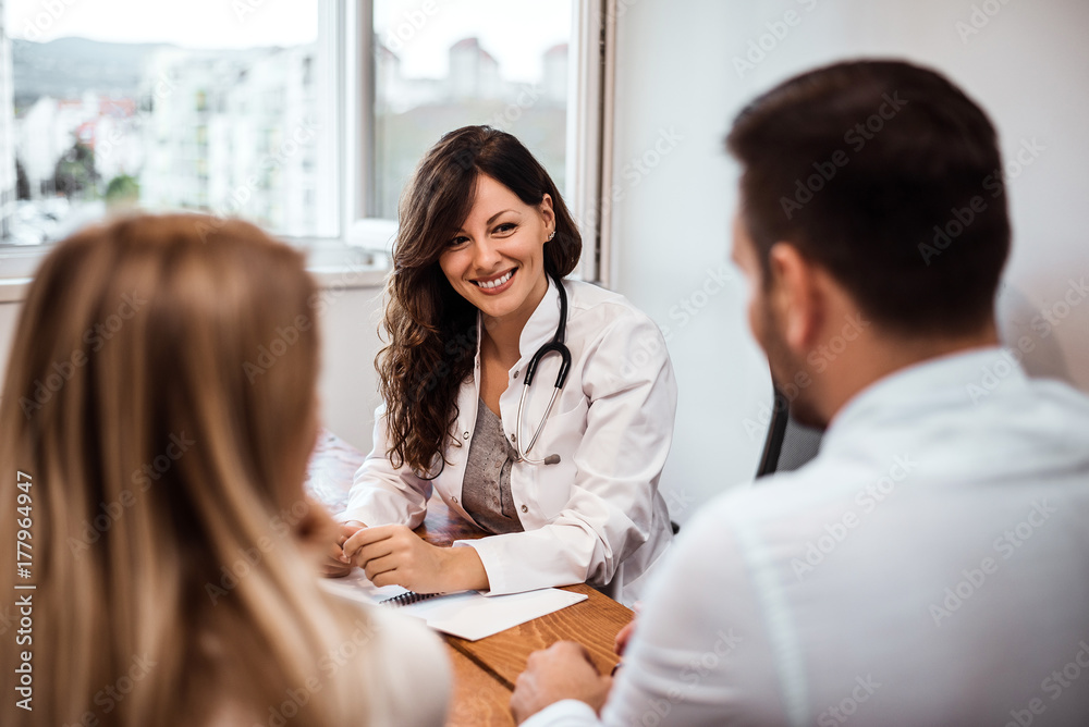 Family couple sitting in doctors office at consultation.