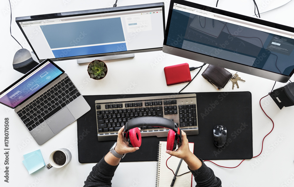 Work desk with multiple screens and electronic devices.