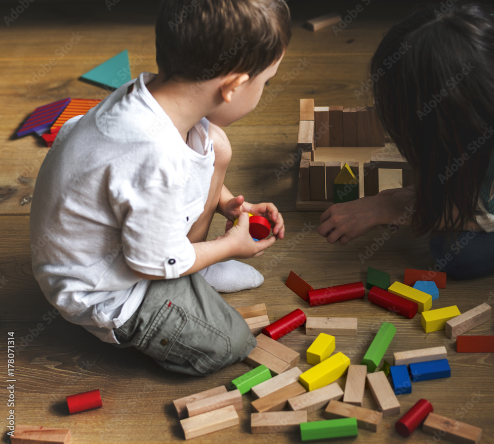 Children having fun playing toy blocks