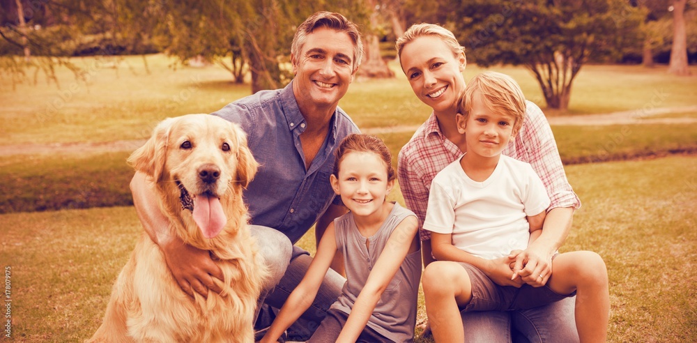 Portrait of family enjoying with dog at park