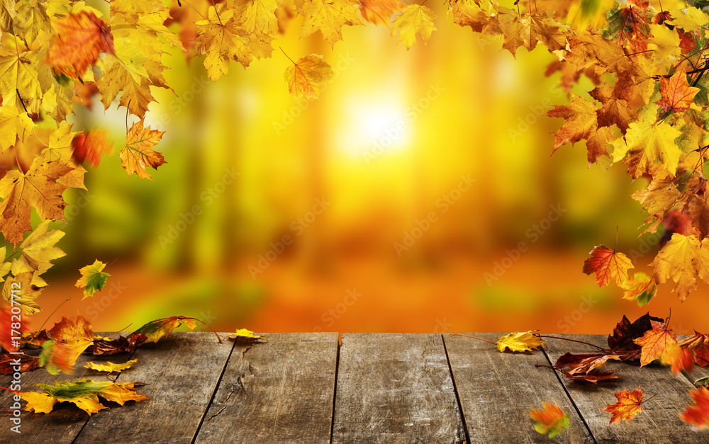 Autumn background with falling leaves and empty wooden table