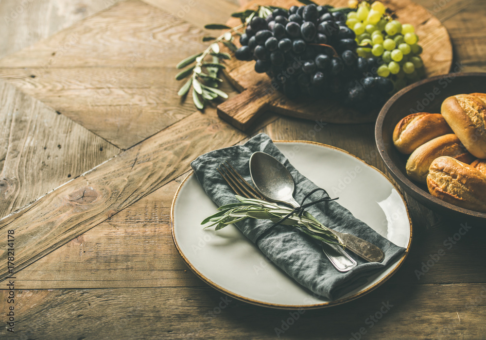 Fall holiday table party decoration setting. Plate with linen napkin, fork, spoon, candle holder, gr