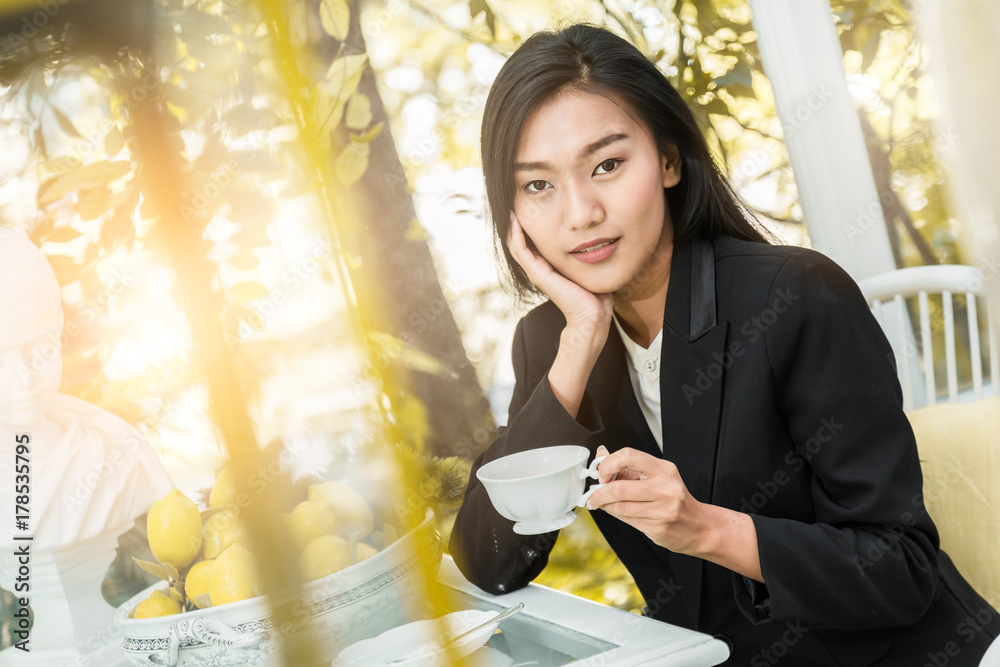 微笑的年轻女人在家里端着一杯绿茶，健康的生活方式理念，亚洲美女，亚洲b