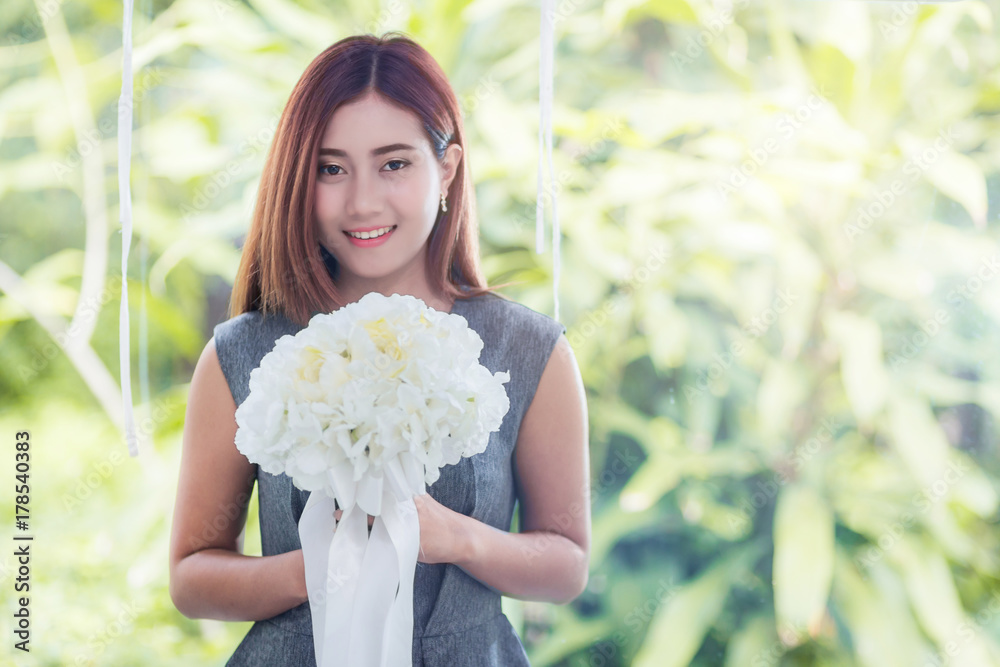 asian beautiful woman with white flower in white gazebo with garden background