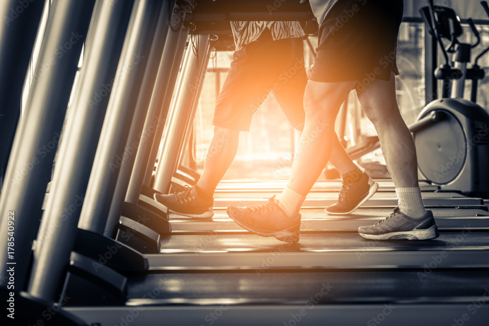 Healthy man and woman running on a treadmill at gym in the morning, The city people health lifestyle