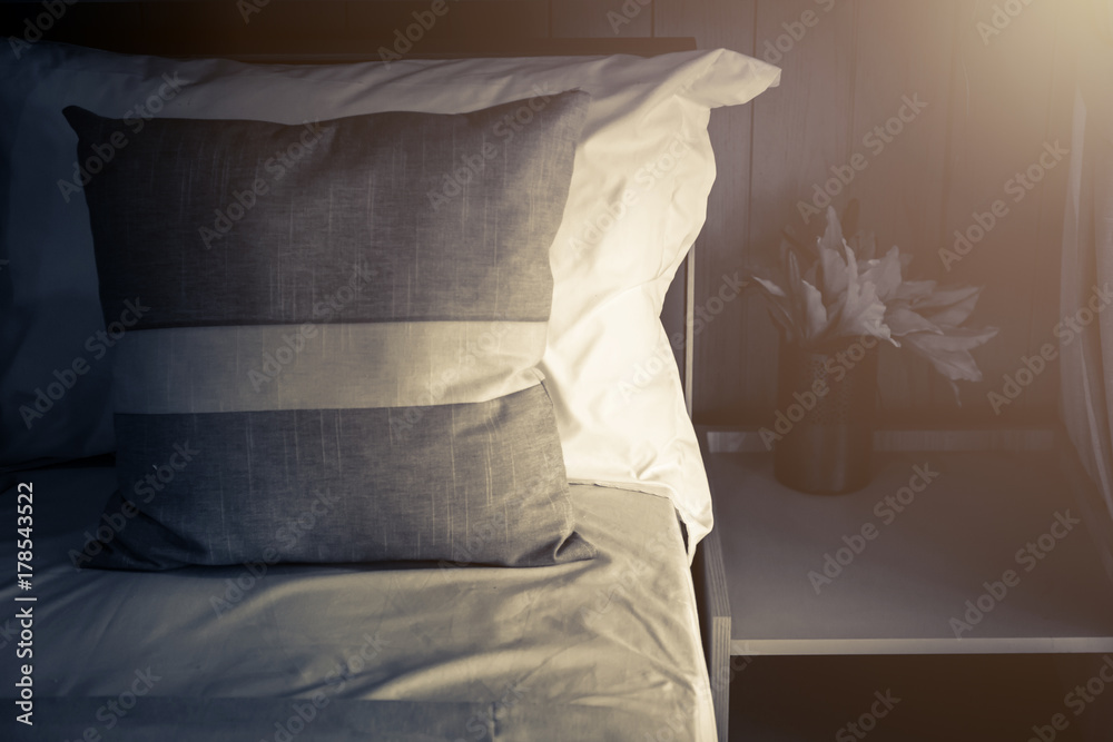 Bed maid-up with clean white pillows and bed sheets in beauty room. Close-up. Lens flair in sunlight