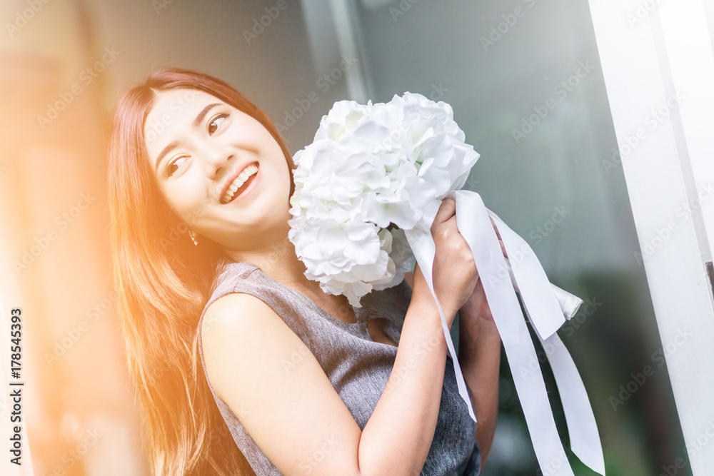 花园背景的白色凉亭里开着白花的亚洲美女