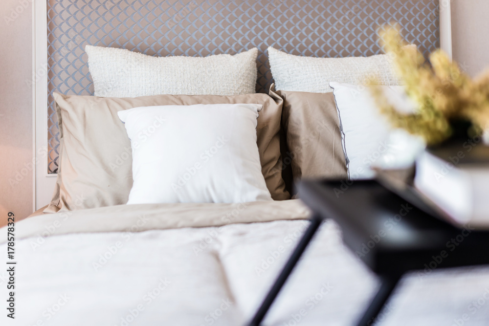 Bed maid-up with clean white pillows and bed sheets in beauty room. Close-up. Lens flair in sunlight