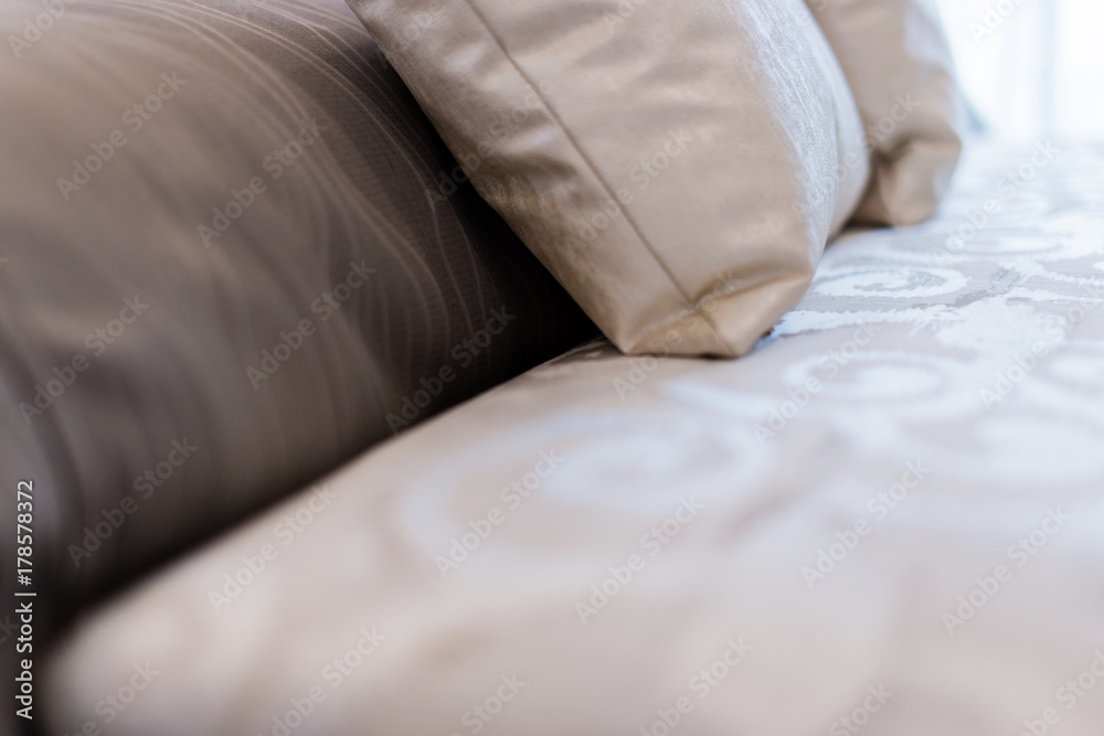 Bed maid-up with clean white pillows and bed sheets in beauty room. Close-up. Lens flair in sunlight