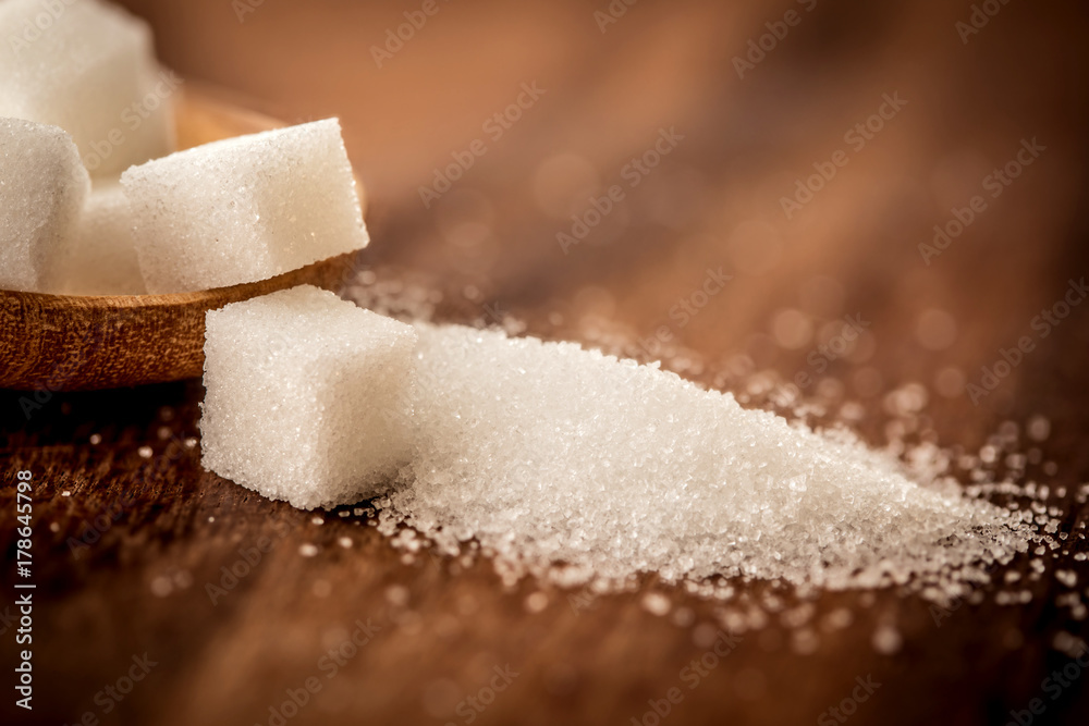  the sugar cubes and cane in wooden spoon on the table ,retro color tone