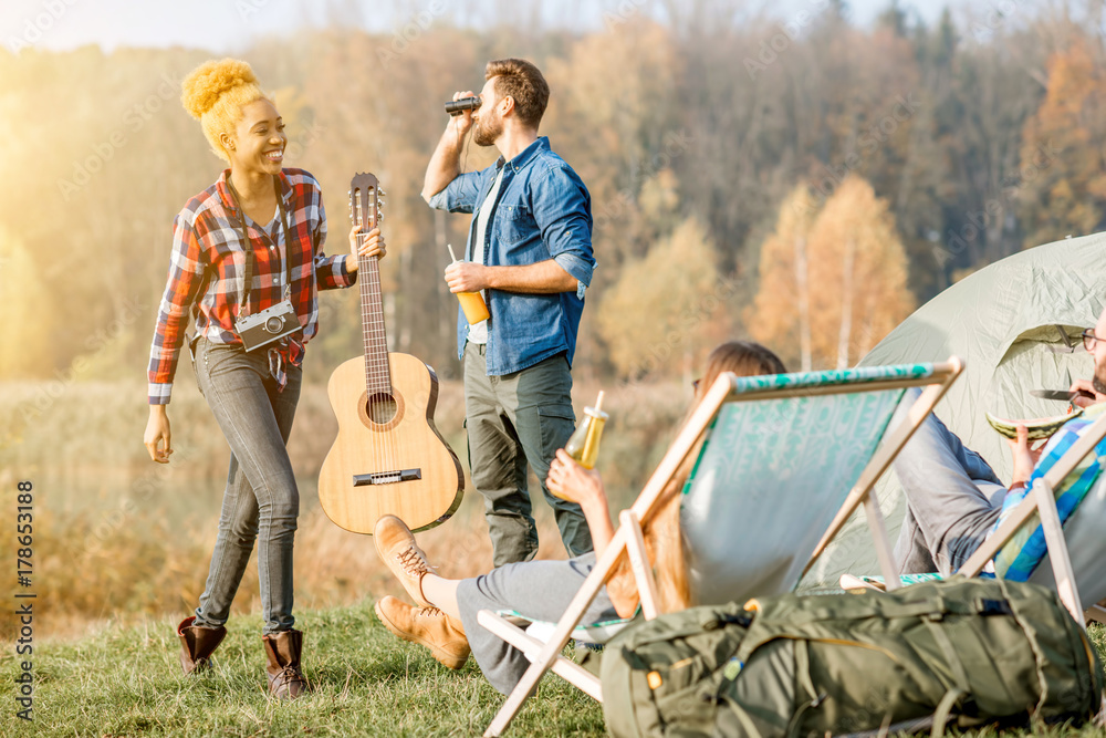 Multi ethnic group of friends dressed casually having fun during the outdoor recreation at the campi