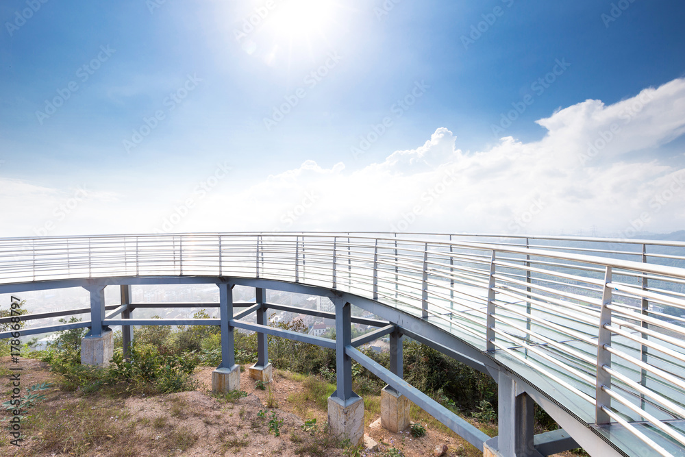 glass pedestrian bridge over hill