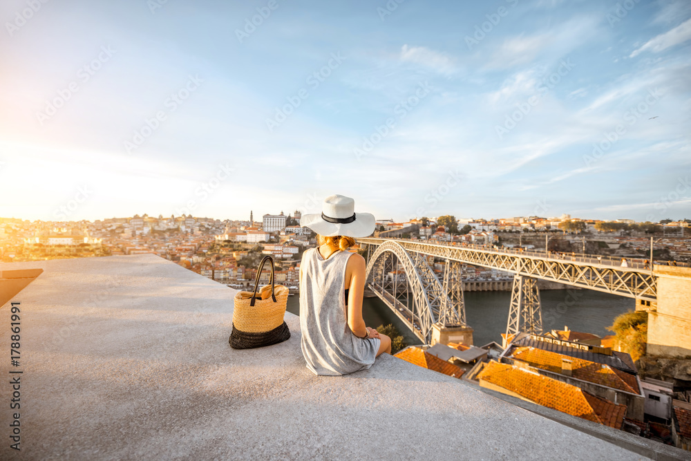 Young woman tourist enjoying beautiful landscape view on the old town with river and famous iron bri