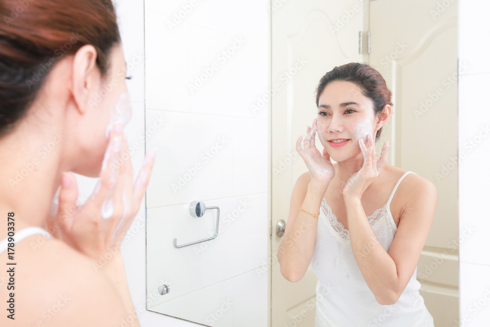 Asian woman cleaning face skin enjoy herself with bubble cleansing foam.