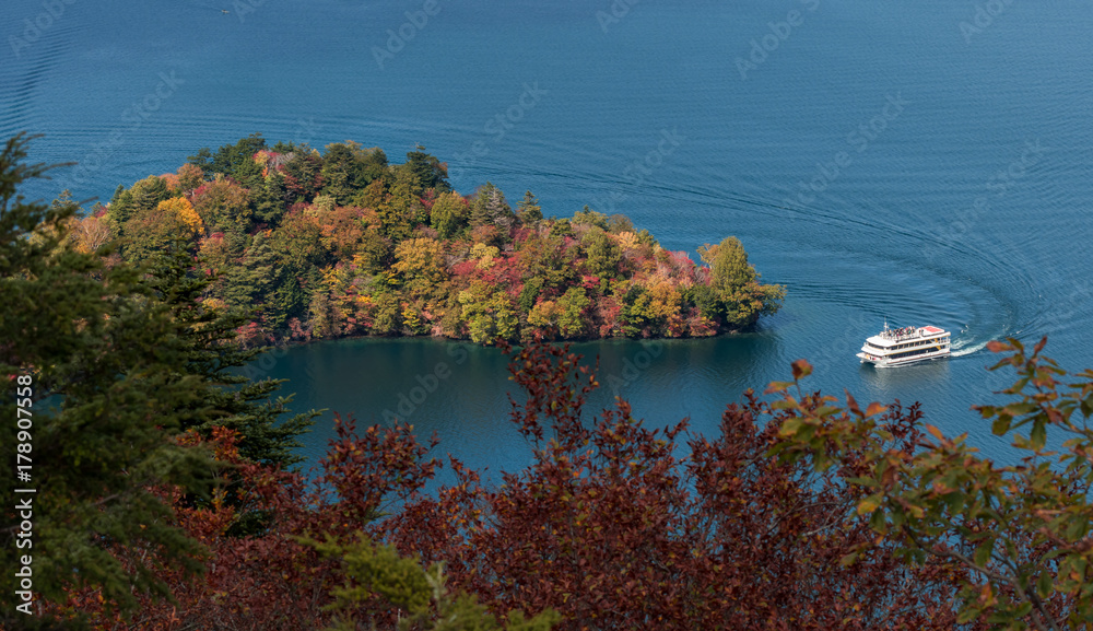 Hacchodejima promontory and sight seeing boat in lake Chuzenji, Nikko, Japan.