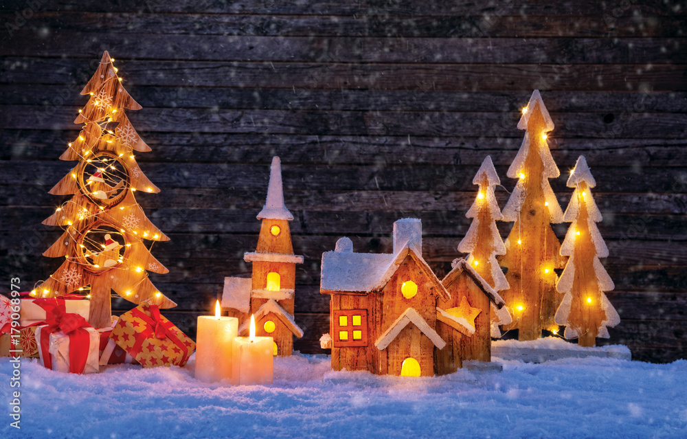 Christmas backgound with illuminated wooden village and christmas tree