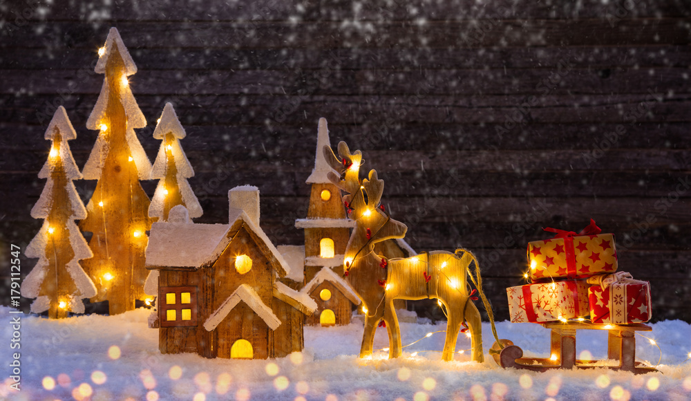 Christmas background with illuminated wooden village and moose