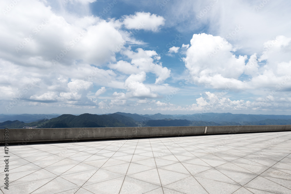 empty marble floor with green hill in cloud sky