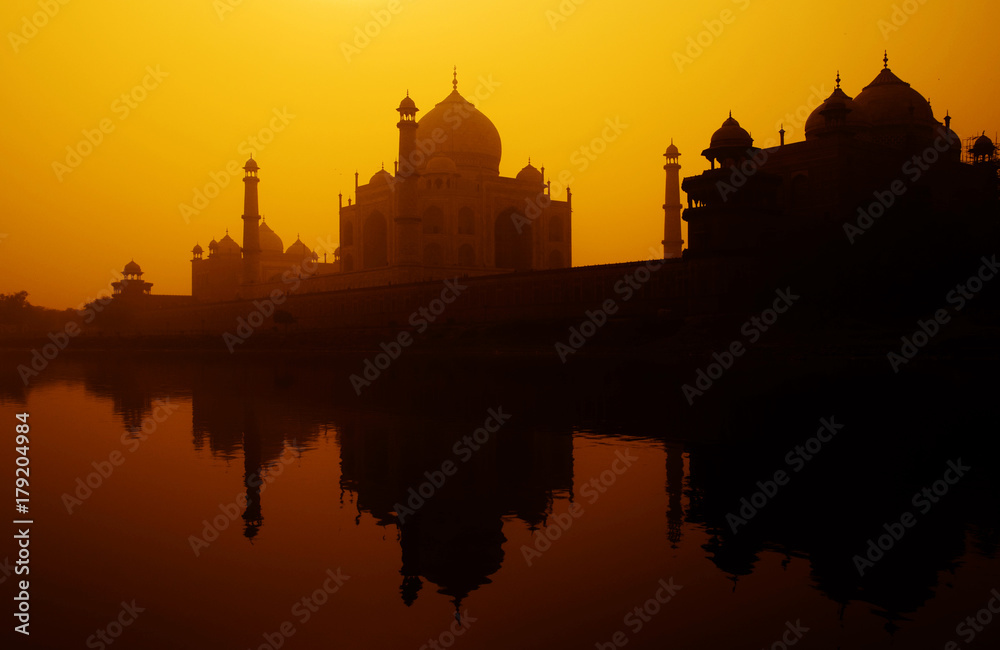 Sunset silhouette of a grand Taj Mahal.