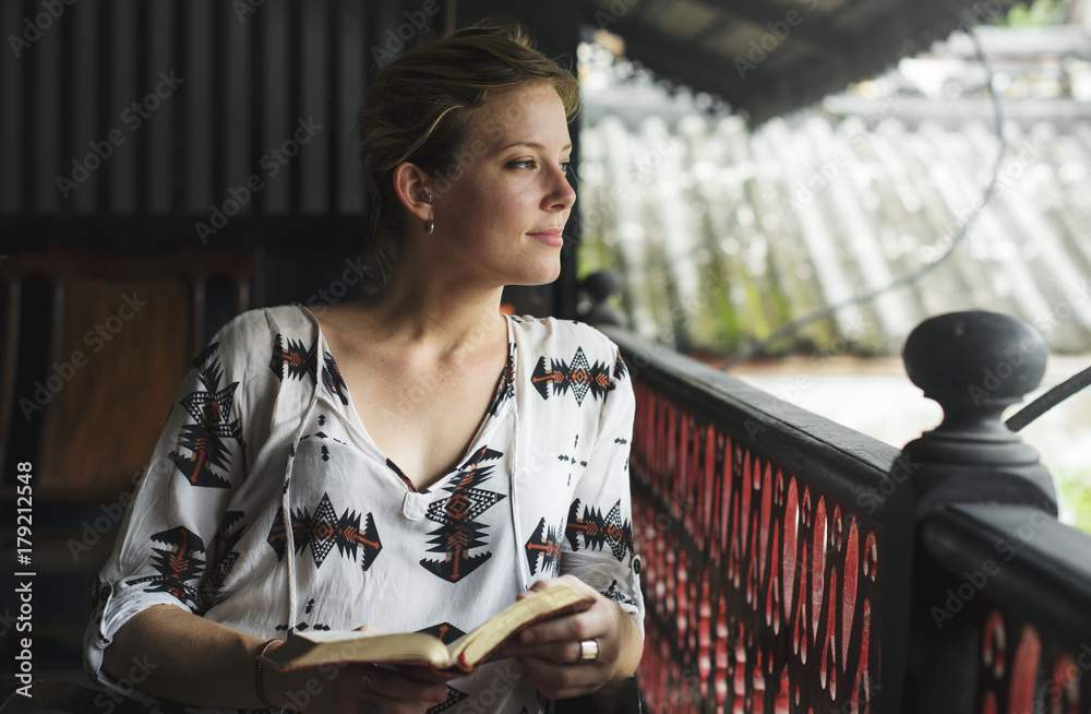 Caucasian woman reading the book at the balcony