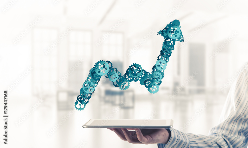 Close of businessman holding tablet pc with progressing graph ic