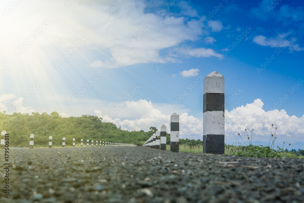 道路旁的黑白石头，有蓝天和阳光。千米石