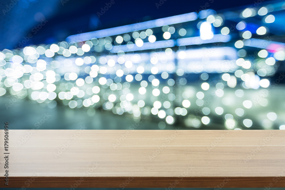 Festive background with light spots and bokeh in front of a empty wooden table